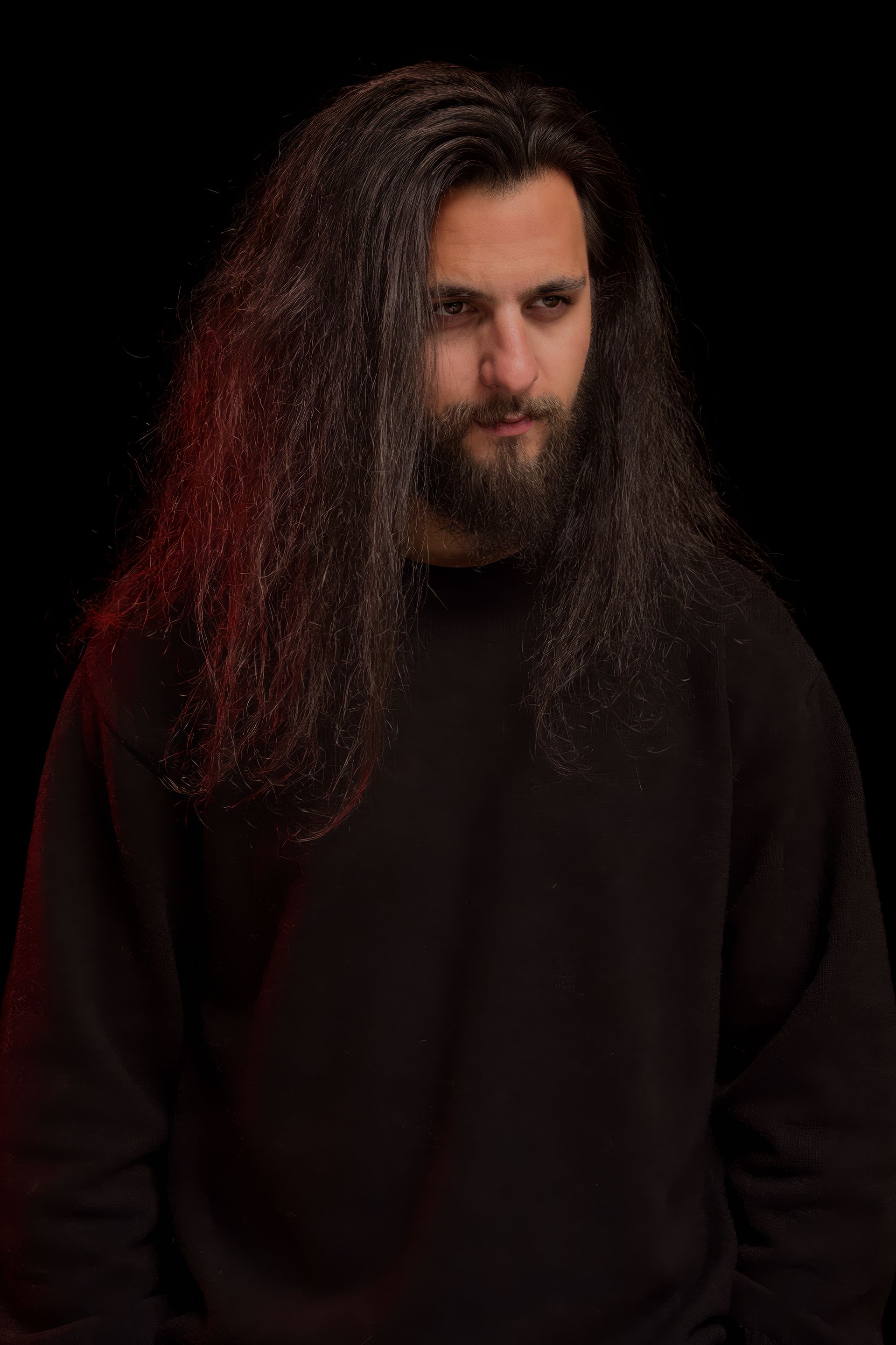 Daniel Costrasel in the dark, looking out, one side of the hair caught by a red light.